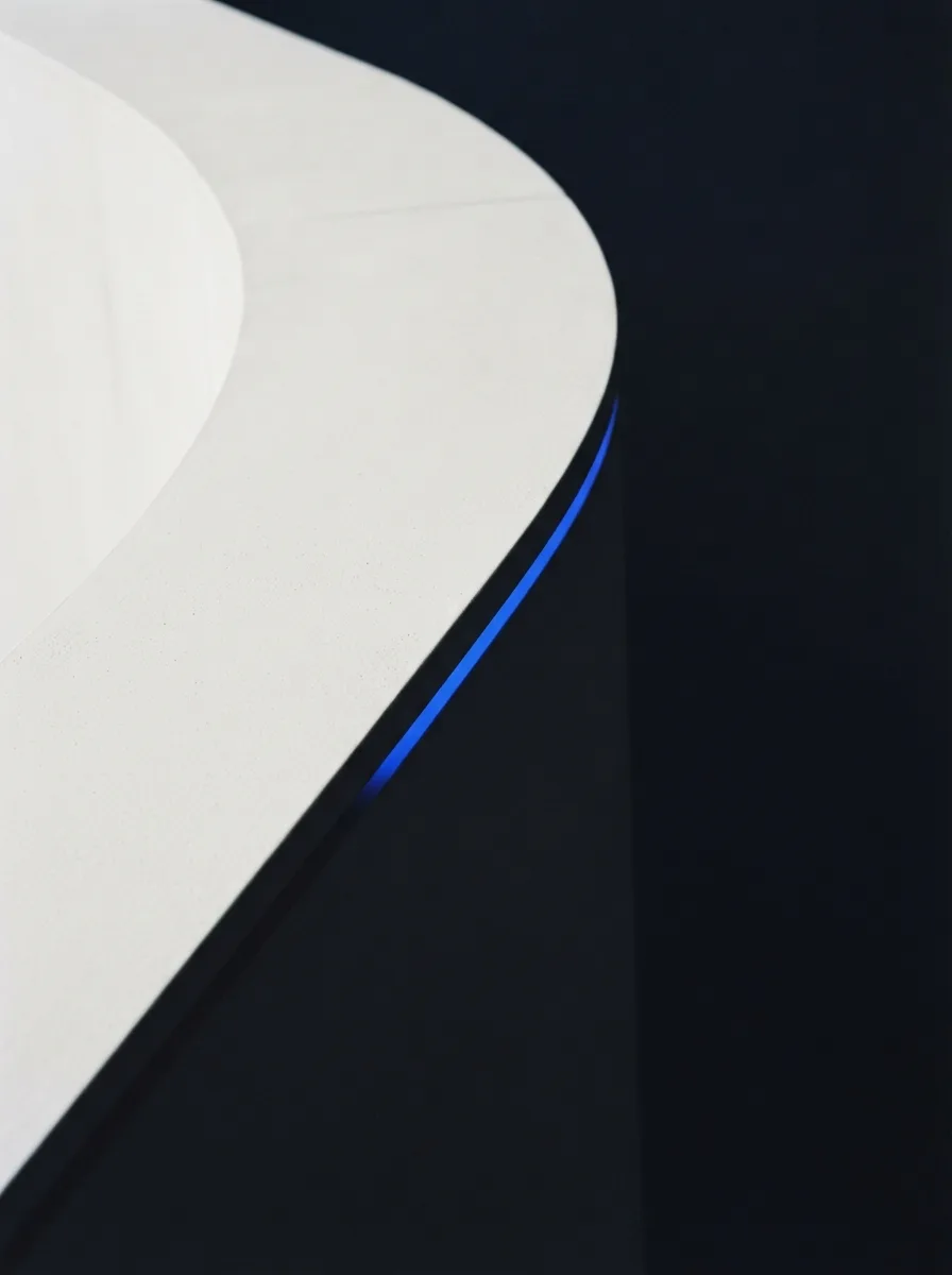 A curved bone-white architectural surface meeting a sharp ink shadow with a blue sliver.